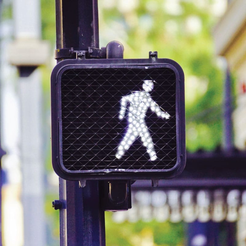 a street sign signaling pedestrians that it is safe to walk