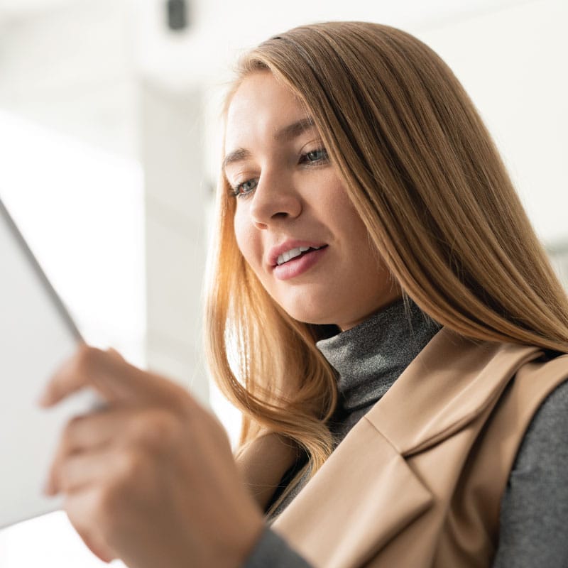 Woman looks at iPad reading a email newsletter from England Injury Law